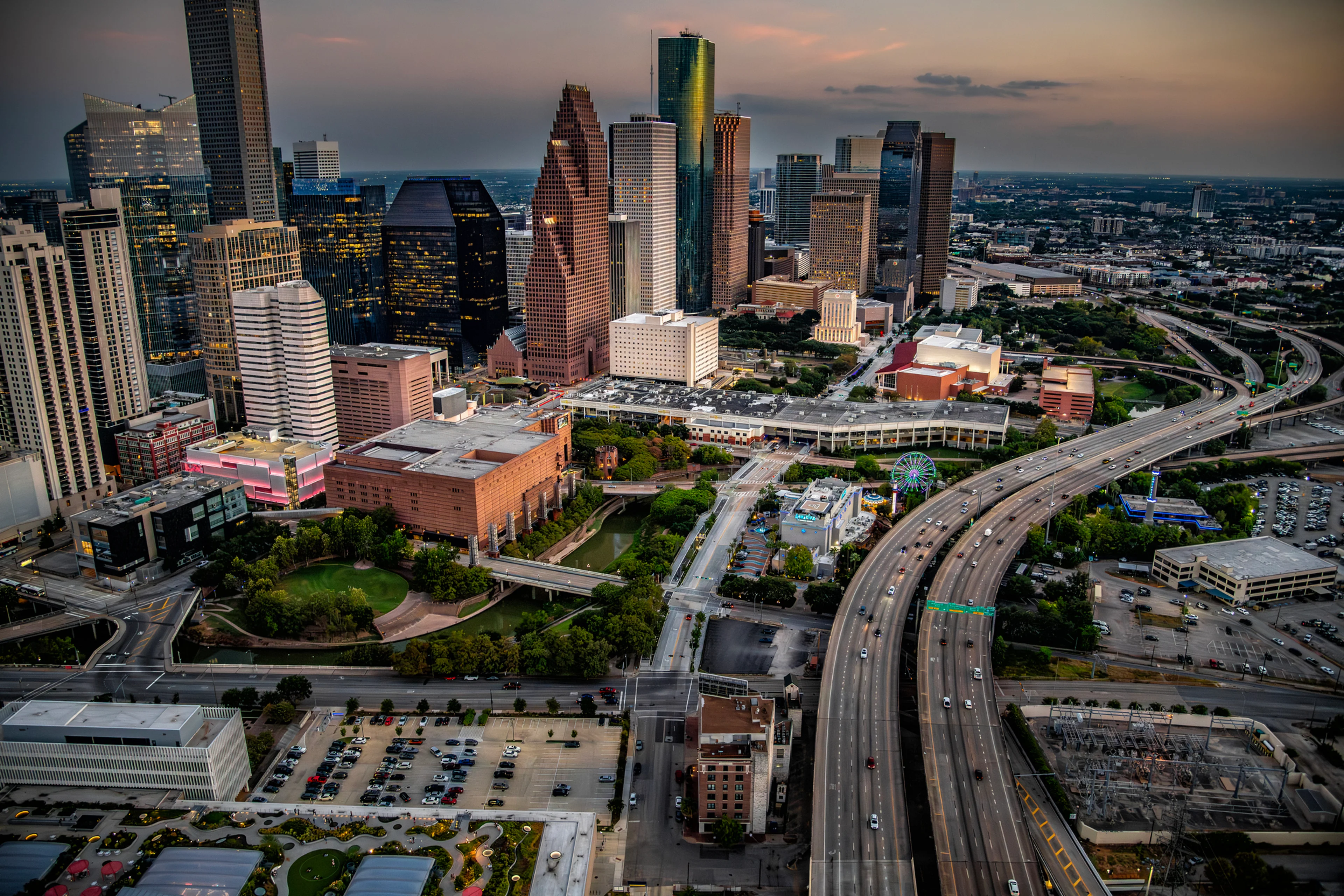 Houston skyline overlooking the highway at dusk.