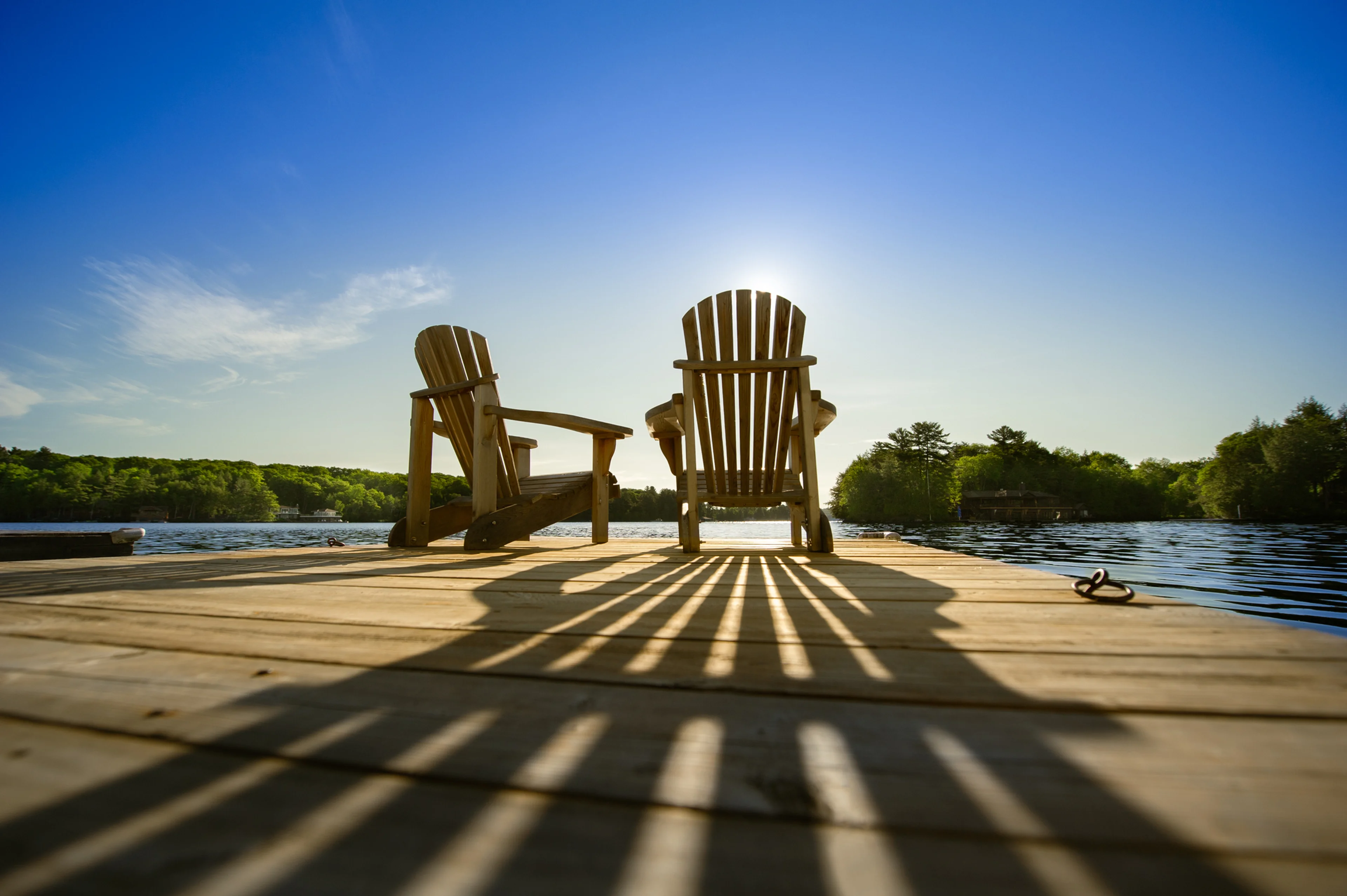 Two empty deck chairs overlooking the lake.